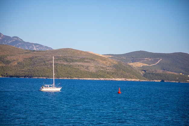 Vista del pequeño yate navegando en mar abierto tranquilo en montenegro