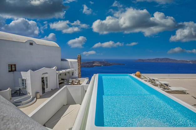 Foto vista perfeita em santorini com arquitetura branca luxuosa piscina infinita sobre navios de cruzeiro mar azul