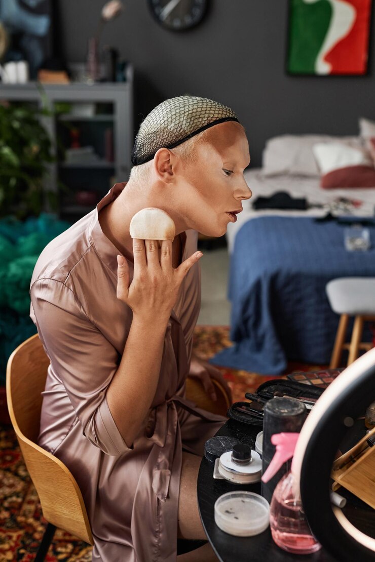 Foto vista del perfil haciendo maquillaje en una habitación de hotel desordenada