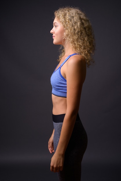 Vista de perfil de joven hermosa mujer deportiva lista para gimnasio