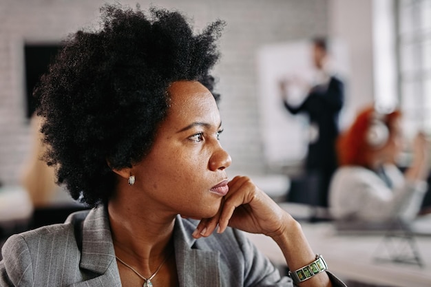 Vista de perfil de una pensativa mujer de negocios afroamericana pensando en algo mientras estaba en la oficina