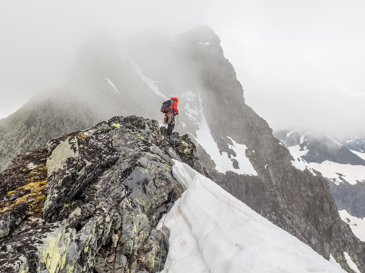 Foto vista de una persona de pie en una montaña cubierta de nieve