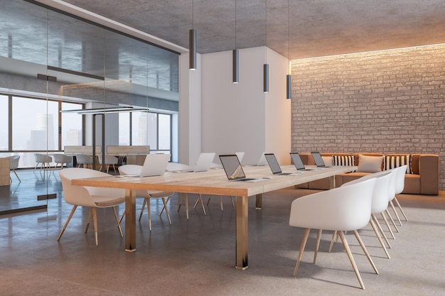 Vista en perspectiva sobre una mesa de conferencias de madera clara con computadoras portátiles modernas rodeadas de sillas blancas en una sala de reuniones iluminada por el sol con un sofá acogedor en la pared de ladrillo y una puerta de vidrio en 3D