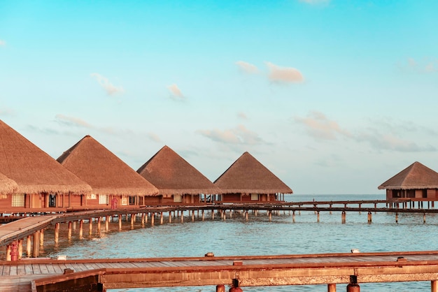 Vista pintoresca de las villas de agua al amanecer en las Maldivas el concepto de viaje de lujo