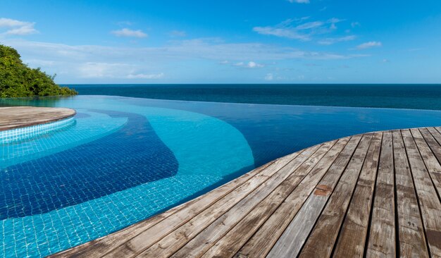 Vista de la piscina infinita al mar y al cielo azul.