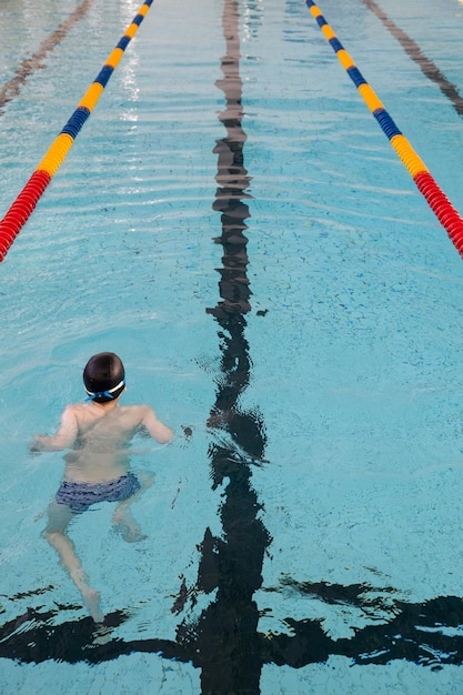 La vista de una piscina pública en el interior Carriles de una competencia Niño entrenando en una piscina