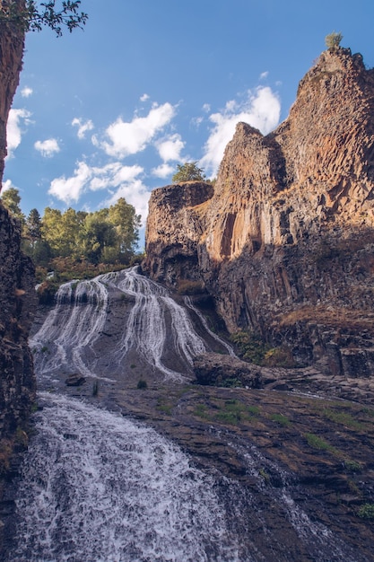 Foto vista pitoresca do fluxo da cachoeira de jermuk entre as rochas do canyon, desfiladeiro iluminado pelo sol, armênio fotografia de stock