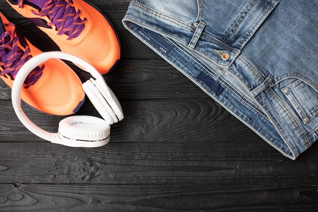 Foto vista plana de jeans y zapatillas sobre fondo de madera