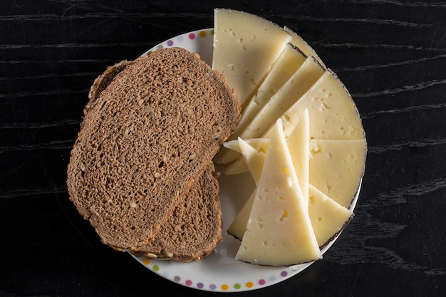 Vista de un plato con queso manchego y pan de centeno plato tradicional en España