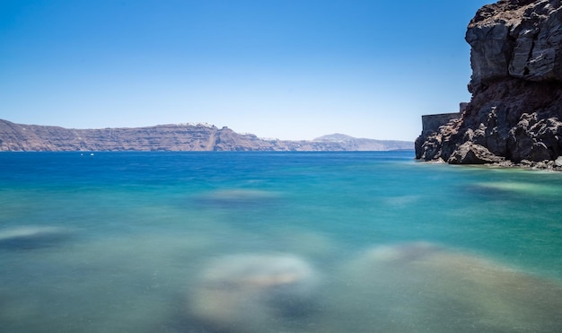 Vista desde la playa del acantilado y la caldera de Santorini día soleado cielo sin nubes