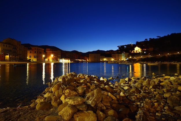 Vista de la playa Baia del Silenzio de noche con luces y reflejos espectaculares