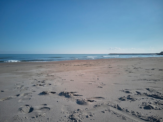 Vista de una playa desierta con impronet en la arena dejada por el paso de quien se ha aventurado a visitar este lugar de paz y tranquilidad.