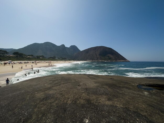 Vista de la playa de Itacoatiara en Niteroi en Río de Janeiro Brasil con sus hermosas colinas que rodean la playa grandes olas en un día soleado de verano