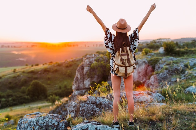 Foto vista posterior de un excursionista femenino con el brazo levantado