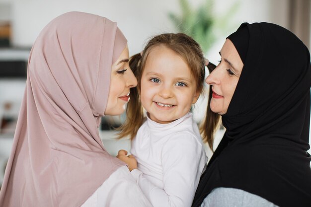 Vista posterior de la familia amorosa de tres generaciones árabes femeninas que muestra dulces sentimientos tiernos
