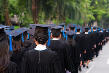 La posterior del grupo de universitarios en vestidos negros alinea para obtener el título en ceremonia de graduación universitaria. felicitación de educación de concepto, estudiante, exitoso para estudiar.