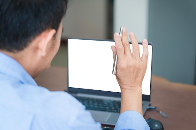 Vista posterior de un hombre asiático hablando en una videollamada con diversos colegas multirraciales en una reunión en línea en una computadora portátil moderna en casa Conceptos de trabajo desde casa