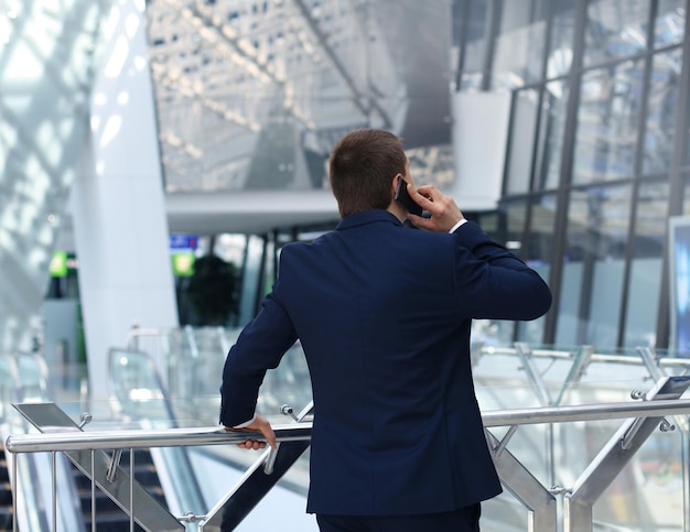 Vista posterior de un hombre de negocios hablando por su teléfono inteligente