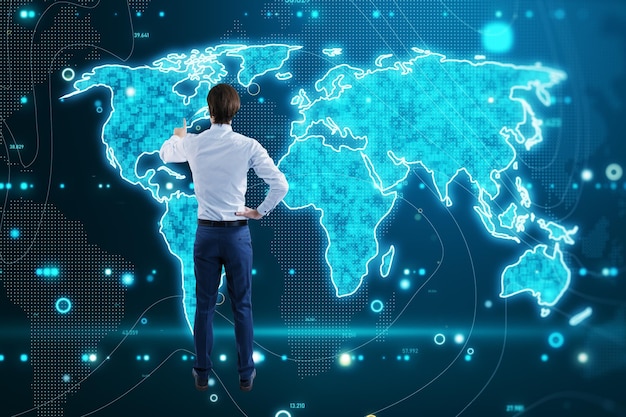 Vista posterior del joven empresario europeo que usa el holograma de pantalla de mapa azul brillante Concepto de tecnología y datos infográficos