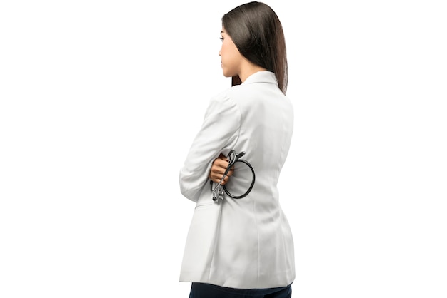 Vista posterior de la mujer asiática del doctor en la capa blanca que sostiene el estetoscopio