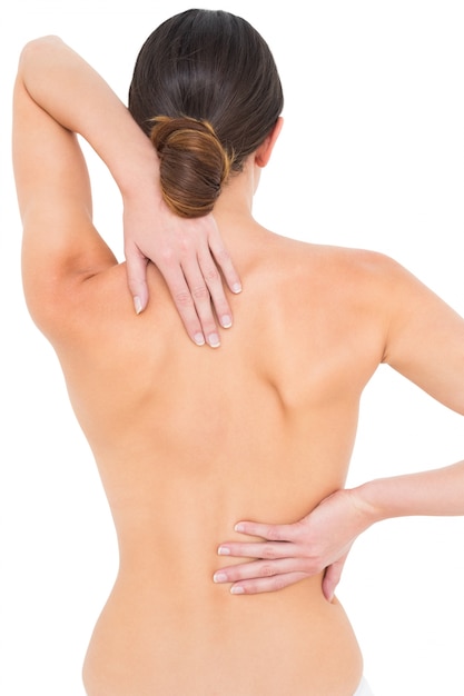 Foto vista posterior de una mujer joven en topless en forma con dolor de espalda