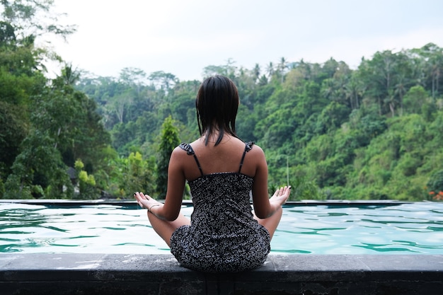 Vista posterior de mujeres jóvenes haciendo pose de yoga con una vista impresionante