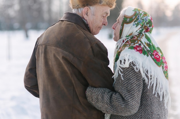 Vista posterior de la pareja de ancianos caminando en el parque felices ancianos juntos aunque los años