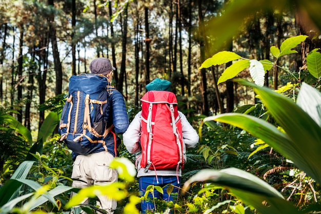 Vista posterior de una pareja de excursionistas asiáticos con mochila explorando