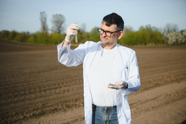 Foto vista pov del propietario del agricultor que controla la calidad del suelo antes de la planta de semillas concepto de agricultura futura