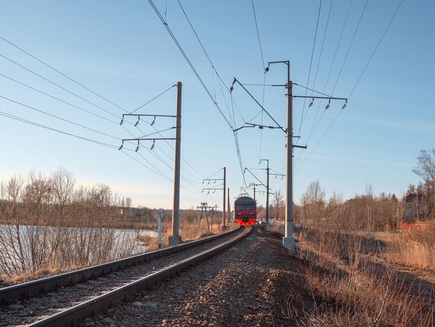 Vista de primavera rústica con un tren Tren suburbano en movimiento Logística de transporte transporte ferroviario