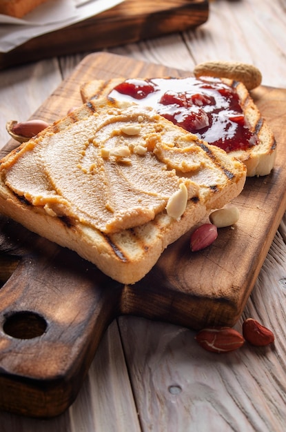 Vista de primer plano de ángulo bajo en sándwiches de mantequilla de maní y mermelada en la tabla de cortar. Concepto de alimentación saludable