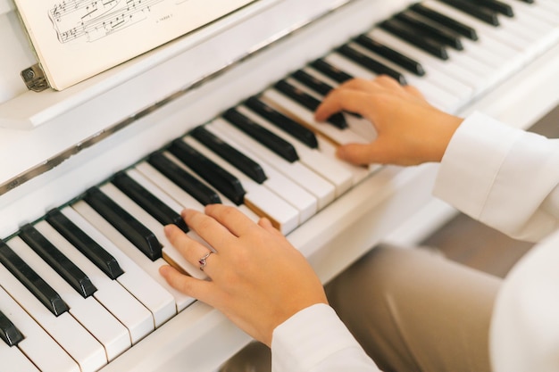 Vista de primer plano de una artista irreconocible tocando el piano clásico en casa disfrutando de música virtuosa en el tiempo libre Pianista practicando clases de piano en un aula ligera