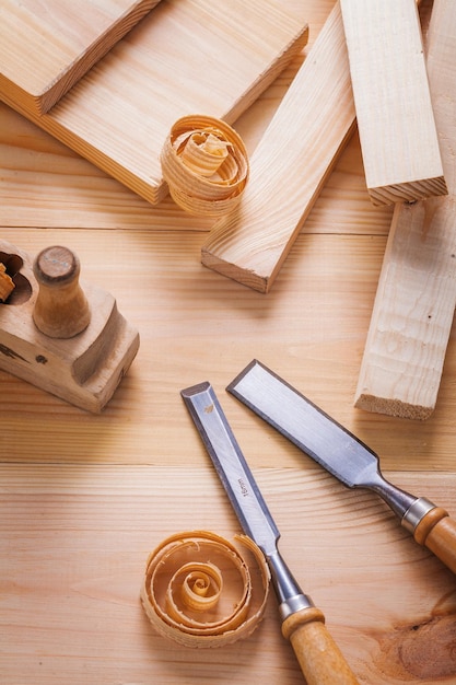 Foto vista de primer plano de la composición en el plano de los carpinteros y cinceles de carpintería con virutas de madera en tableros