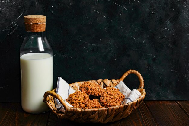 Vista de primer plano de las galletas de avena Pila de deliciosas galletas de avena enrolladas caseras en una servilleta de mesa copos de avena y una botella de leche Fondo de la mesa del desayuno de la mañana Foto de alta calidad