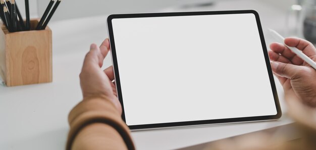 Vista de primer plano del joven con tableta de pantalla en blanco en la oficina moderna