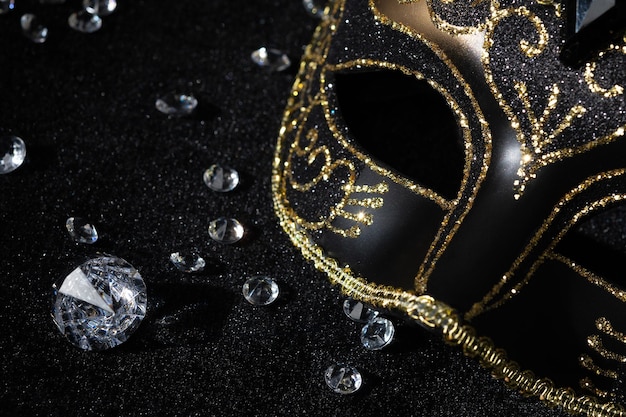 Foto vista en primer plano de la máscara de oro de masquerade con piedras preciosas en fondo negro