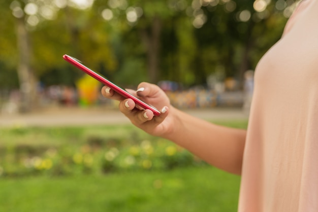 Vista de primer plano de los mensajes de texto femenino en el parque