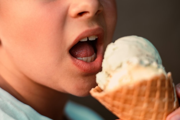 Foto vista en primer plano de un niño comiendo helado en una taza de gofres macro vista detallada de una lengua en helado niñez feliz en verano
