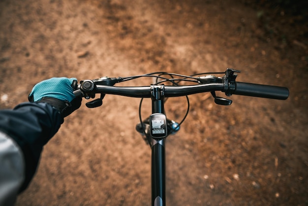 Vista en primera persona del manejo de la bicicleta en el camino forestal de la ciudad hacia la luz del sol Concepto de uso de una bicicleta para deportes y recreación fuera de una ciudad