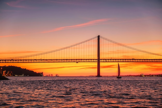 Vista del puente de Abril sobre el río Tajo al atardecer en Lisboa, Portugal