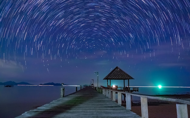 Vista del puente de madera con movimiento de exposición a la velocidad del cielo nocturno