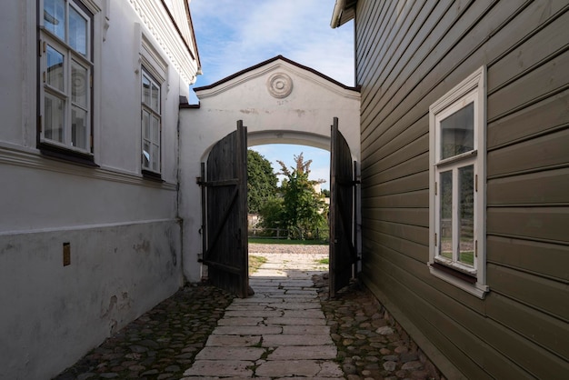 Vista de la puerta de madera al patio de una finca comercial tradicional en la calle principal de la calle Izborsk Pechorskaya en un día soleado de verano Izborsk Pskov región Rusia