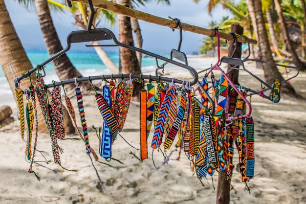 Vista de la pulsera hecha a mano de cuentas de colores en una percha en una playa