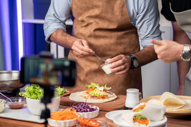 Vista recortada de los chefs influyentes que presentan un rollo de ensalada fresco