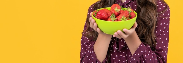 vista recortada de un cuenco de fresas para adolescentes en un fondo amarillo