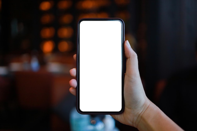 Vista recortada das mãos femininas segurando o telefone celular em branco com cópia em branco da tela do telefone inteligente com o conceito de tecnologia