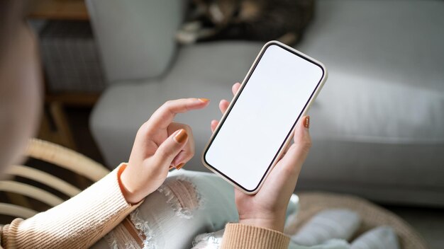 Vista recortada das mãos femininas segurando o telefone celular em branco com cópia em branco da tela do telefone inteligente com o conceito de tecnologia