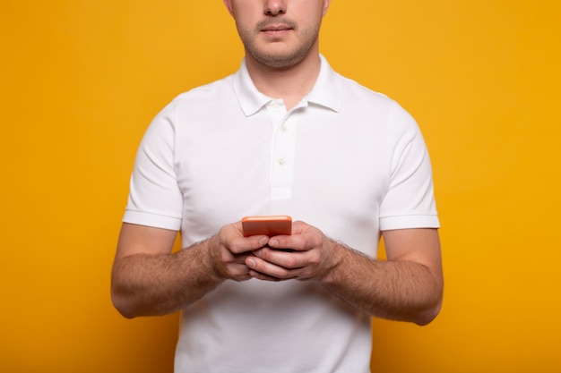 Vista recortada del hombre con smartphone en amarillo