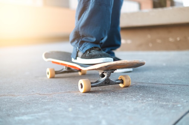 Vista recortada de un joven patinando en un parque de patinaje con zapatillas negras en patineta