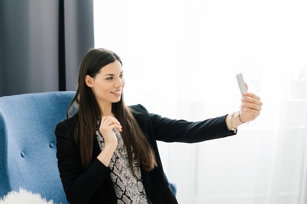 Vista recortada de manos femeninas sosteniendo teléfonos inteligentes. Mujer con teléfono celular en casa. Enfoque selectivo